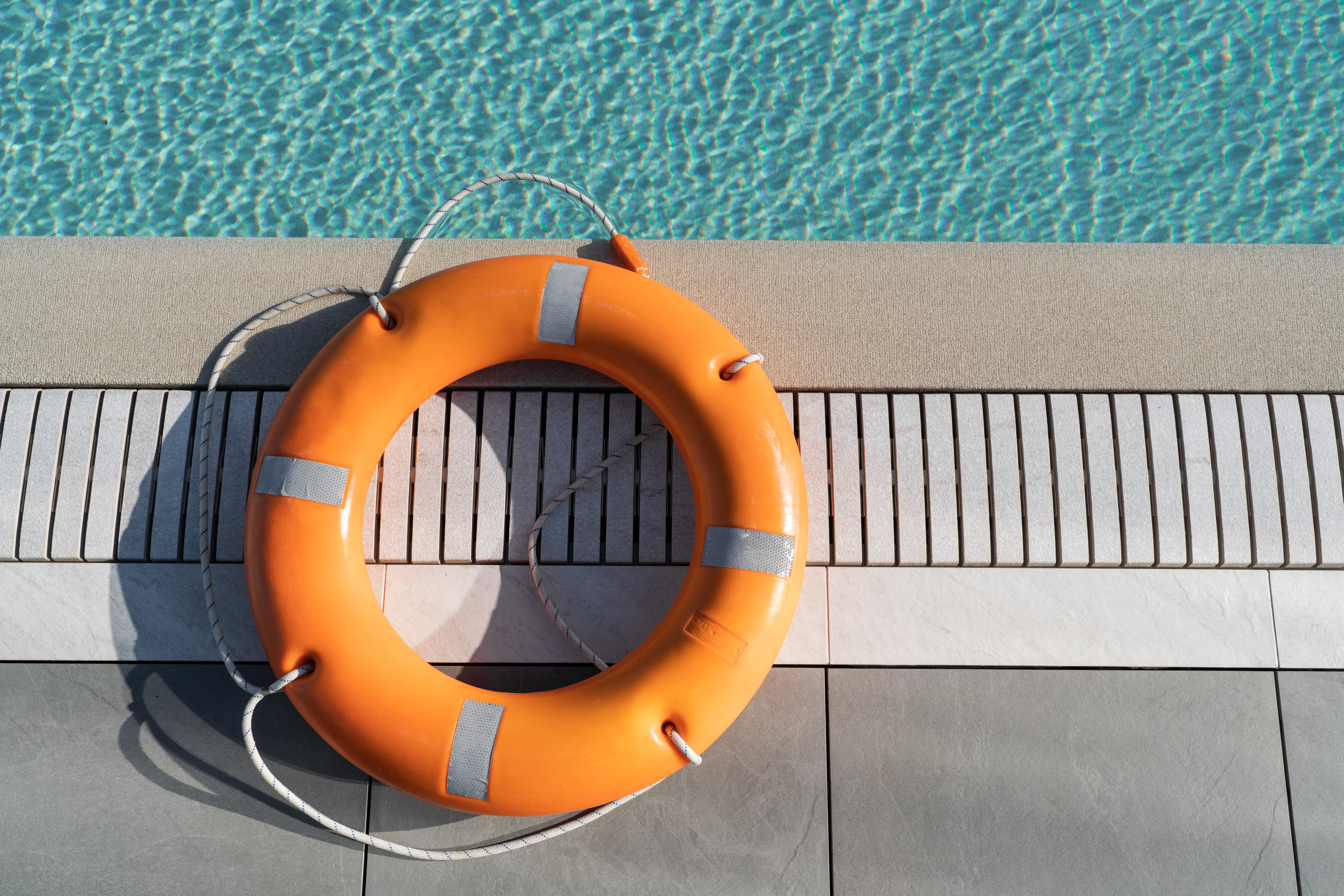 Orange lifebuoy by the pool. Lifebuoy, rescue concept